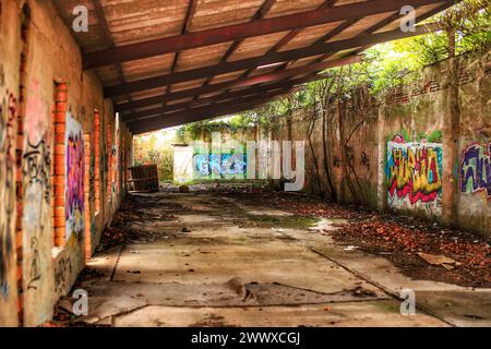 Area di stoccaggio abbandonata della fabbrica con graffiti. Foto Stock