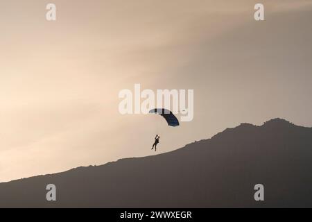 Riprese di Mission Impossible Dead Reckoning parte 1. Tom Cruise in paracadutismo verso le colline del Lake District intorno a Buttermere, Cumbria, Regno Unito. Foto Stock