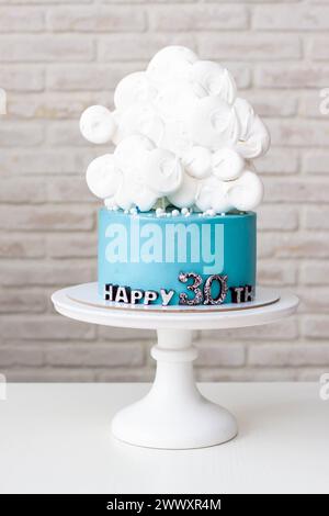 Torta di compleanno blu con nuvole bianche per il 30° anniversario su sfondo neutro Foto Stock
