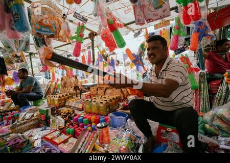 Il venditore vende articoli per festeggiare Holi in un mercato di strada, in vista del festival Holi il 23 marzo 2024 a Guwahati, Assam, India. Holi è l'indù Foto Stock