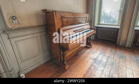 Pianoforte antico trascurato in una stanza abbandonata con pavimento in legno, Villa Woodstock, Lost Place, Brill, Wuppertal, Renania settentrionale-Vestfalia, Germania Foto Stock