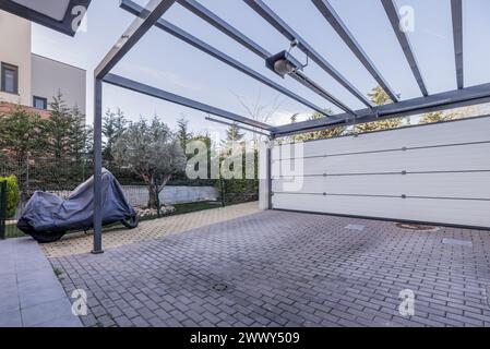 Portico d'ingresso con struttura in metallo e cancello motorizzato di una casa unifamiliare con splendidi giardini Foto Stock