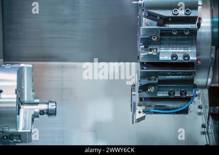 La macchina per tornio CNC che forma il taglio delle parti metalliche. Lavorazione di metalli ad alta tecnologia mediante tornitura CNC . Fotografia di alta qualità. Foto Stock