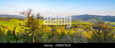 Una vista panoramica di Jested Ridge al tramonto, catturata da un lussureggiante campo verde. L'atmosfera serena e i colori vivaci creano un paesaggio mozzafiato. Situato nella Repubblica Ceca. Foto Stock