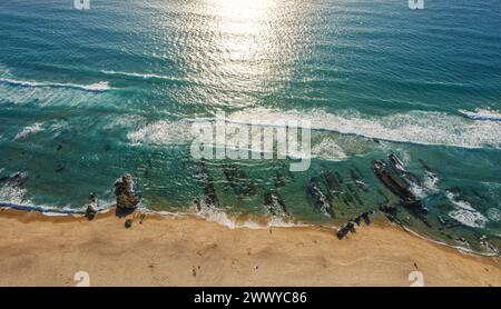 Onde spumeggianti dell'oceano che si avvicinano alla costa sabbiosa. Vista dall'alto. Foto Stock