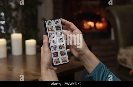 Ordinare cibo tramite smartphone a casa. Una donna seleziona il cibo estaurante nel menu Internet di un ristorante gourmet utilizzando un'applicazione su uno smartp Foto Stock