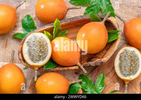 Granadilla con foglie su tavola di legno. Vista dall'alto. Foto Stock