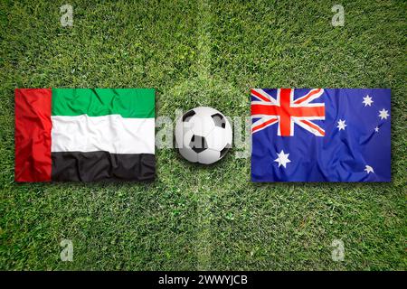 Emirati Arabi Uniti vs. Australia bandiere sul verde del campo di calcio Foto Stock