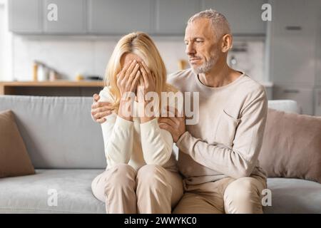 Coppia che si conforta a vicenda in momenti di sofferenza Foto Stock