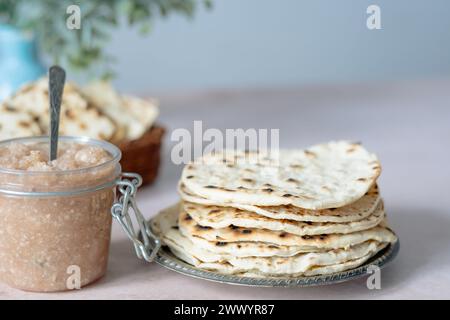 Matzo rotondo fatto a mano in un piatto. Condimento dolce con caroset di mele e noci sul tavolo. Cibo sano. Festeggiamenti ebraici di Pasqua. spazio per il testo Foto Stock