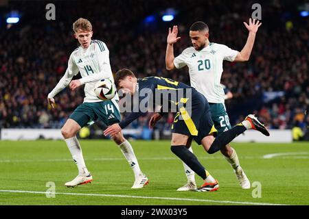 Nathan Patterson (centro) della Scozia combatte per il ballo con Isaac Price (sinistra) e Brodie Spencer dell'Irlanda del Nord durante un'amichevole internazionale a Hampden Park, Glasgow. Data foto: Martedì 26 marzo 2024. Foto Stock