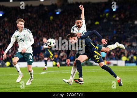 Nathan Patterson (centro) della Scozia combatte per il ballo con Isaac Price (sinistra) e Brodie Spencer dell'Irlanda del Nord durante un'amichevole internazionale a Hampden Park, Glasgow. Data foto: Martedì 26 marzo 2024. Foto Stock