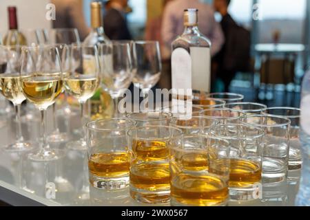 Molti bicchieri con scotch, brandy e sibilo stanno al bar. Varie bevande alcoliche in bicchieri a buffet durante la festa. Foto Stock