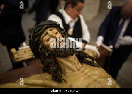 Madrid, Madrid, Spagna. 26 marzo 2024. Membri della Congregazione reale del Santo Cristo della fede, del Cristo degli alberdieri e di Maria Immacolata Regina degli Angeli, puliscono l'immagine del Cristo degli alberdieri dalla pioggia all'interno del Palazzo reale dopo aver completato il trasferimento e i preparativi, per uscire in processione il prossimo venerdì Santo per le strade di Madrid. (Immagine di credito: © Luis Soto/ZUMA Press Wire) SOLO PER USO EDITORIALE! Non per USO commerciale! Foto Stock