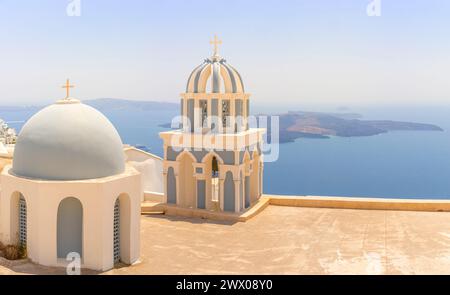 Le iconiche cupole sull'isola greca di Santorini si affacciano sul vulcano centrale sul mare Egeo. Foto Stock