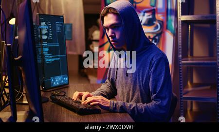 Lone lupo hacker in nascondiglio segreto che cerca di nascondere la sua attività online dopo aver rubato dati alle vittime usando virus informatici, cercando di evitare di essere scoperto, colpo molto ravvicinato Foto Stock