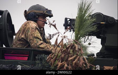 Un soldato assegnato al 3rd Battalion, 69th Armor Regiment, 1st Armored Brigade Combat Team, 3rd Infantry Division, esplora l'area dalla cima di un M1 Abrams Tank presso il Joint Readiness Training Center (JRTC) a Fort Johnson, Louisiana, 16 marzo 2024. I soldati pattugliarono le loro aree e risposero ai contatti nemici simulati durante le loro due settimane di addestramento al JRTC. (Foto dell'esercito degli Stati Uniti di PFC. Luciano Alcala) Foto Stock