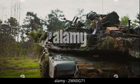 Un soldato dell'esercito degli Stati Uniti assegnato al 3rd Battalion, 69th Armor Regiment, 1st Armored Brigade Combat Team, 3rd Infantry Division, esplora l'area circostante dal portello del caricatore di un M1A2 Abrams Main Battle Tank presso il Joint Readiness Training Center (JRTC) a Fort Johnson, Louisiana, 18 marzo 2024. I soldati si addestrarono contro forze ostili simulate in un ambiente di addestramento realistico durante le loro due settimane di addestramento al JRTC. (Foto dell'esercito degli Stati Uniti di PFC. Luciano Alcala) Foto Stock