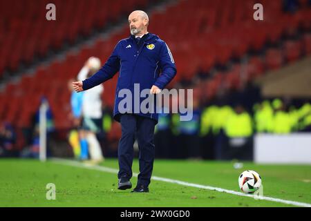 26 marzo 2024; Hampden Park, Glasgow, Scozia: Amichevole internazionale di calcio, Scozia contro Irlanda del Nord; il manager scozzese Steve Clarke calcia una palla di riserva dal campo durante la partita Foto Stock