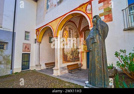 La statua in bronzo del frate francescano Bartolomeo de Ivrea e gli affreschi conservati nel chiostro del Santuario della Madonna del Sasso, Orselina, Svizzera Foto Stock