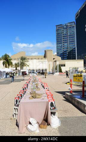 Un'installazione di un tavolo da pranzo di sabato con sedie per gli ostaggi a Gaza in Piazza degli ostaggi, Tel-Aviv, Israele. Foto Stock