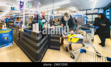 Amburgo, Germania. 22 marzo 2024. Clienti che fanno acquisti in un supermercato a prezzi scontati LIDL. Credito: Markus Scholz/dpa/Alamy Live News Foto Stock