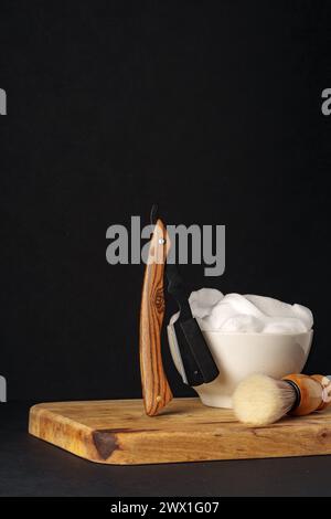 Apparecchiatura di rasatura classica con rasoio, spazzola e sapone su supporto in legno su sfondo scuro Foto Stock