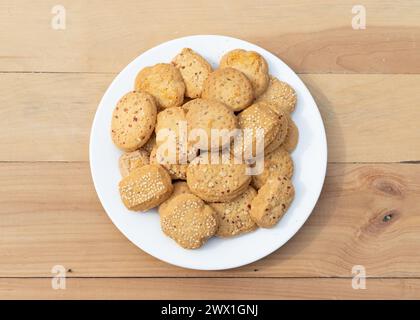 Biscotti e biscotti diversi in ceramica bianca su fondo in legno Foto Stock