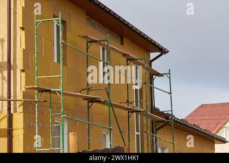 Isolamento termico a parete esterna con lana minerale. Isolare la facciata dell'edificio commerciale. Efficienza energetica Foto Stock