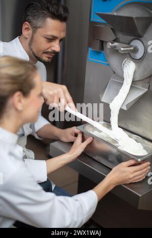 il pasticcere decora una torta in un negozio di dolciumi Foto Stock