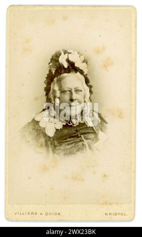 Originale Victorian carte de visite (Visiting Card o CDV) ritratto di una donna vittoriana di mezza età più anziana, sorridente, dall'aspetto gentile, in abiti neri e indossa un cofano rivestito di pizzo, lunghi capelli grigi ricci, studio di Villiers e Quick, Bristol, Regno Unito circa 1870 Foto Stock