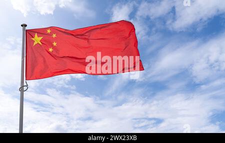 La bandiera cinese sta sventolando nel vento. Simbolo della Cina. Foto Stock