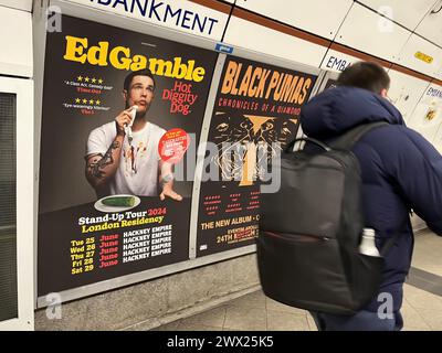 Un poster che pubblicizza il tour Hot Diggity Dog di ed Gamble sulla piattaforma della Bakerloo line alla stazione della metropolitana Embankment a Londra. Il comico ed Gamble è stato costretto a rimuovere una foto di un hot dog dai suoi poster dopo aver violato la politica pubblicitaria di TfL sulla presenza di cibi ricchi di grassi, zucchero e sale. Il comico ha invece scambiato l'hot dog con un cetriolo per ottenere il materiale promozionale in mostra. Data foto: Mercoledì 27 marzo 2024. Foto Stock