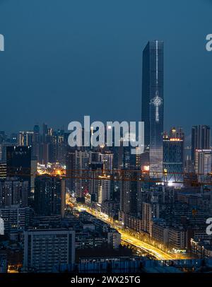 Una vista aerea del vivace paesaggio urbano notturno con grattacieli illuminati a Wuhan, Cina Foto Stock