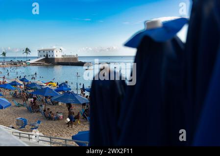 Salvador, Bahia, Brasile - 01 giugno 2019: Vista degli ombrelloni e del forte di Santa Maria sullo sfondo sulla spiaggia di Porto da barra nella città di Salvador, Bah Foto Stock