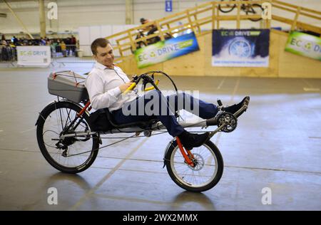 Uomo che corre su una bicicletta elettrica fatta in casa su una pista ciclabile. Bike Expo-2019. 8 marzo 2019. Kiev, Ucraina Foto Stock