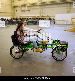 Uomo e donna che cavalcano una bicicletta elettrica fatta in casa su una pista ciclabile. Bike Expo-2019. 8 marzo 2019. Kiev, Ucraina Foto Stock