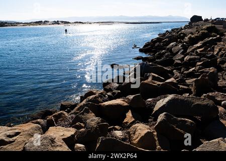 Paddle boarder a Morro Rock e Morro Bay, Oceano Pacifico, Morro Bay, California, Stati Uniti. Foto Stock