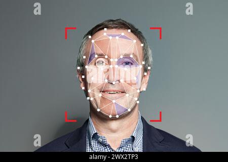 Riconoscimento facciale di un uomo d'affari anziano. Uomo maturo con sistema di sicurezza biometrico tecnologico Foto Stock