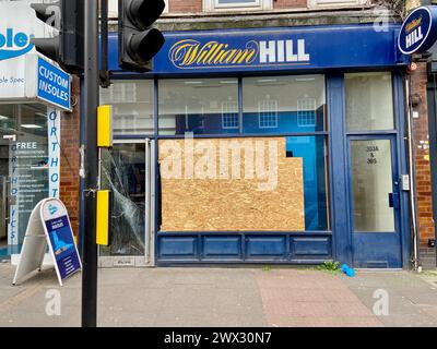 Un negozio di scommesse william Hill a muswell Hill N10 londra, inghilterra, con una porta frantumata e una finestra frontale sostituita da compensato Foto Stock