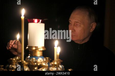 Novo-Ogaryovo, Russia. 24 marzo 2024. Il presidente russo Vladimir Putin accende una candela in omaggio alle persone uccise nel municipio di Crocus attentato terroristico dalla residenza presidenziale di Novo-Ogaryovo, 24 marzo 2024 fuori Mosca, Russia. Almeno 130 civili sono stati uccisi dai terroristi dello Stato islamico in un attacco contro una sede di concerti. Crediti: Mikhail Metzel/piscina del Cremlino/Alamy Live News Foto Stock