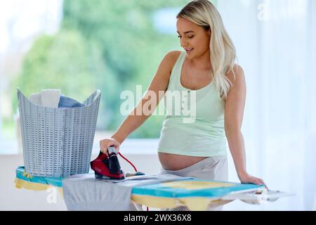 Donna incinta servizio stireria Foto Stock