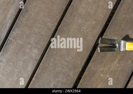 Chiodi dalla testa di un martello metallico poggiati su alcune tavole di legno Foto Stock