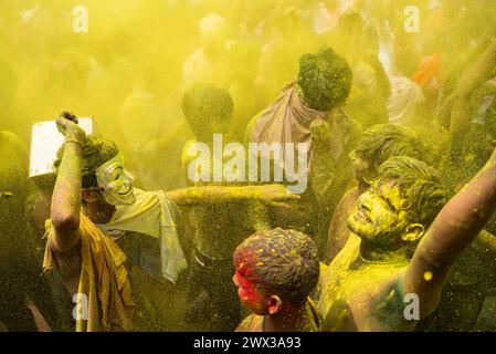 I rivelatori che ballano al ritmo della musica mentre celebrano Holi su una strada, il festival primaverile indù dei colori il 25 marzo 2024 a Guwahati, Assam Foto Stock