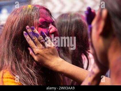 I rivelatori che ballano al ritmo della musica mentre celebrano Holi su una strada, il festival primaverile indù dei colori il 25 marzo 2024 a Guwahati, Assam Foto Stock