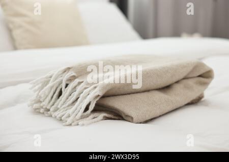 Morbido piatto beige sul letto in camera da letto Foto Stock