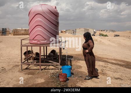 Raqqa, Siria. 2 ottobre 2023. Chris Huby/le Pictorium - Siria - la difficile ricostruzione di Raqqa - 02/10/2023 - Siria/siria settentrionale/Raqqa - campo informale di Hattash - Una donna versa acqua nel suo secchio. La ONG Solidarites International è riuscita a installare un sistema di distribuzione. Crediti: LE PICTORIUM/Alamy Live News Foto Stock