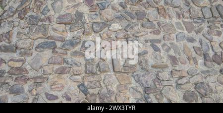 Pavimentazione in ciottoli con pietre di quarzite. Superficie stradale del complesso monumentale, Caceres, Spagna Foto Stock