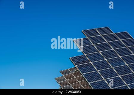 due file di pannelli solari nel parco solare per la produzione di energia fotovoltaica nelle giornate di sole con sfondo blu cielo Foto Stock