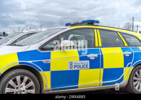 Angolo basso, vista laterale ravvicinata dell'auto della polizia di West Mercia (lato passeggero, lato marciapiede) parcheggiata isolata all'aperto senza persone. Veicolo per la risposta in caso di incidente. Foto Stock